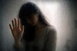 © danialiman - A woman seen behind foggy glass, using subtle visual metaphor to convey vulnerability and isolation.