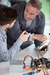 © auremar - portrait of a man and apprentice working on electronic factory
