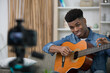© auremar - handsome music blogger holding and describing acoustic guitar