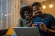 © Nenad - Happy couple having fun while online shopping at home.