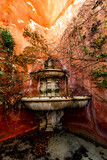 Stone fountain nestled in rustic Spanish architecture in Seville