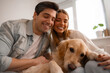 © My Ocean studio - Affectionate couple cuddling with their golden retriever