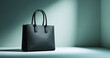 © perfectlab - A black leather tote bag with a pebbled texture and top handles sits on display against a green backdrop