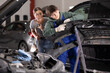 © JackF - Young guy mechanic advises young woman client on repairing bumper in car service station
