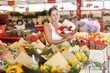 © JackF - Happy young girl buyer holding bouquet of flowers in large plants market