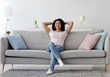 © Prostock-studio - Enjoy freedom, weekend and spare time at home. Happy millennial pretty african american woman rest in silence and cleanliness of new apartment after moving, in living room interior, empty space