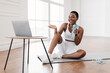 © Prostock-studio - Online Exercise Session Marathon, Remote Training. Happy millennial black female sitting on mat and talking with coach, having videocall with teacher, taking break from virtual workout drinking water