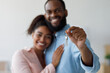 © Prostock-studio - Smiling young afro american couple hugging and show keys to new property at home interior. Happy owners express positive emotions from buying new apartment, family moving to new house, free space