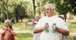 © DavidsPrime/peopleimages.com - Dumbbell, fitness and class with old man in park for retirement, weightlifting exercise and health club. Muscle growth, wellness and weights with senior people for low impact workout and instructor