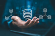 © Nirusmee - Engineer holding database icons, representing data integration, ETL processes, data pipelines, and centralized data warehouse solutions for efficient data management and analysis.