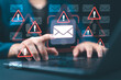 © Nirusmee - Email security software detecting phishing or scam emails with warning alerts, as a businessperson touches the email icon to delete malicious messages and protect sensitive data.