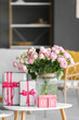 © Pixel-Shot - Calendar with date of International Women's Day, roses and gift boxes on table in living room, closeup