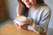 © Farknot Architect - Closeup image of a woman holding a cup of hot latte coffee