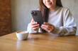 © Farknot Architect - Closeup image of a woman holding and using mobile phone in cafe