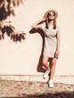 © halayalex - Young beautiful smiling hipster woman in trendy summer clothes. Sexy carefree woman posing on the street background at sunset. Positive model outdoors. Cheerful and happy in sunglasses and hat