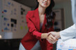 © Tj - Professional business women in blazers shaking hands, collaborating on a new project, and confirming a deal, establishing a strong and reliable partnership in an office setting