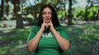 © Krakenimages.com - Plus size woman volunteering in park wearing a green shirt, joyfully engaging in outdoor activities with a vibrant background of trees and grass under the sunlight.