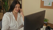 © Krakenimages.com - Woman working at office desk on phone with computer in a professional setting, showcasing a young plus size woman in business environment.