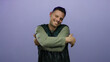 © Krakenimages.com - Young man embraces himself with a smile over an isolated purple background wearing casual attire depicting warmth and self-love.