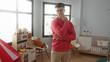 © Krakenimages.com - Young man in pink sweater thoughtfully standing in modern nursery room with crib, soft toys, and bright natural lighting, conveying a serene and cozy domestic atmosphere.