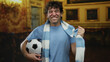 © Krakenimages.com - Man in museum holding soccer ball wearing blue scarf and shirt with joyful expression showcasing hispanic identity and love for sport in cultural setting.