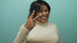 © Krakenimages.com - Hispanic woman counting fingers smiling against green background, showcasing positive expressions and gestures, radiating confidence and joy.