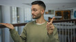 © Krakenimages.com - Young hispanic man gesturing in hotel lobby suggests denial or indecision while presenting something with open hand, indicating a decision point or contemplation situation.
