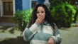 © Krakenimages.com - Woman with glasses surprised outdoors on street wearing striped sweater in daylight with trees in background, showcasing curious and expressive hispanic female reaction.