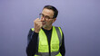 © Krakenimages.com - Hispanic man in a yellow vest shows anger by raising his fist against a purple wall background, illustrating emotion and frustration in a mature male expression.