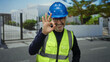© Krakenimages.com - Man in helmet and vest smiles and makes 'okay' sign in urban outdoor setting, showcasing positive attitude and safety on city street during daytime.