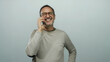 © Krakenimages.com - Man smiling while talking on phone against plain white background, conveying happiness and connection.