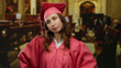 © Krakenimages.com - Graduate woman standing in church wearing pink gown and cap, expressing confidence, with church interior blurred, symbolizing achievement and education pride.