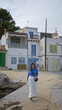 © Krakenimages.com - Woman walking in old town featuring mediterranean architecture on mallorca coast with charming buildings in the background, capturing a blend of history and scenic beauty.