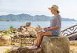 © efired - Woman is working on a laptop at a scenic location