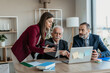 © Vladimir Borovic - Multi-Generational Business Team Explaining Work to Senior Executive in Modern Office – Family Business Concept