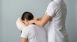 © D-point - Woman receiving a neck and shoulder massage from a professional female therapist in a portable massage chair. Health and wellness.