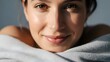 © Tur - Close Up Portrait of a Smiling Young Woman with Brown Eyes and Dewy Skin in Soft Natural Lighting Against a Neutral Gray Background