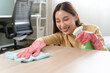© Pormezz - happy Female housekeeper service worker wiping table surface by cleaner product to clean dust.