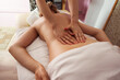 © timofeev - Close-up of a spa therapist hands gliding over a young woman bare back during relaxing massage, warm soft light highlighting smooth skin, cozy treatment room and tranquil wellness atmosphere.