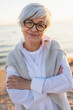 © Юлия Завалишина - Outdoor portrait of confident stylish European middle aged senior woman. Older mature lady smiling on beach. Happy attractive senior female looking camera close up face headshot portrait. Happy people