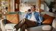 © stockbusters - Cheerful guy gossiping cellphone at couch home closeup. Man enjoy friendly call