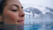 © OleksandrZastrozhnov - Relaxed caucasian woman enjoying warm outdoor pool amidst snowy mountains