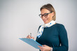© Nenad - Photo of gorgeous blond secretary woman with short hair writing down notes in clipboard while working in office