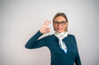 © Nenad - Confident woman in office giving ok sign with empty background