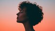 © Peter@studio5 - A silhouetted profile of a woman against a vibrant sunset, showcasing her curly hair and serene expression.