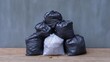© Lifestyle Images - Pile of black garbage bags stacked on top of each other on a wooden surface. the bags are of different sizes and shapes, with the largest bag at the bottom and the smallest at the top.
