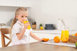 © Pixel-Shot - Cute little girl drinking orange juice in kitchen