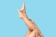 © Pixel-Shot - Legs of young woman on blue background. Epilation concept