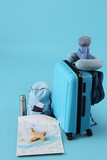 Suitcase with travelling accessories on blue background