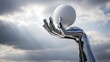 © My universe - Chrome metallic hand reaching up to hold white sphere against dramatic cloudy sky with sunbeams